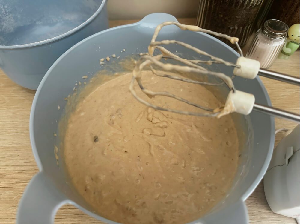 Kokosmilch und Bananenpüree mit dem geschlagenen Teig verrühren, vierter Schritt für den Bananenkuchen-Teig.